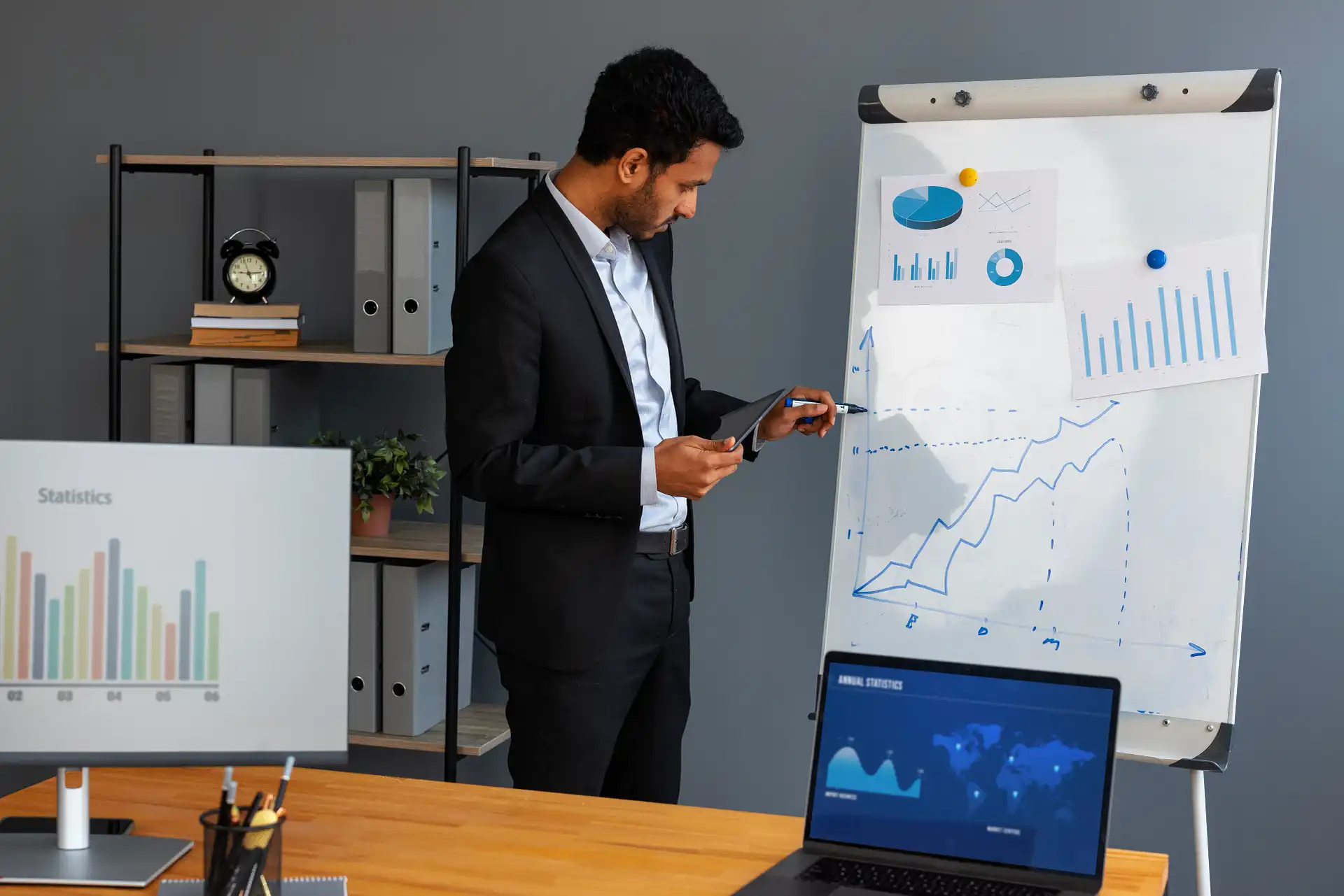 Research analyst reviewing charts and reports to understand data analysis requirements.